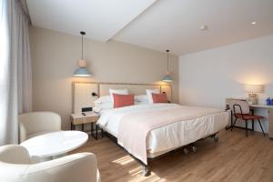 1 dormitorio con 1 cama, mesa y sillas en Óbal Urban Hotel, en Marbella