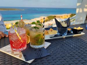 2 bebidas en una mesa con vistas a la playa en Villa Chiccolina, en Stintino