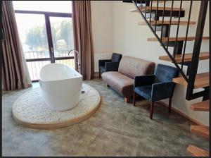 a living room with a white bath tub and chairs at Osonnya Karpaty RESORT MEDICAL & SPA in Skhidnitsa