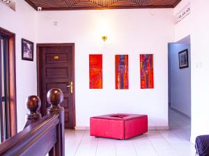 a room with a red ottoman in front of a door at Explorers Hub in Kampala