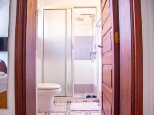 a bathroom with a toilet and a shower at Explorers Hub in Kampala