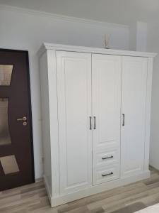 a white cabinet in a room with a door at Apartament Eva in Râşnov