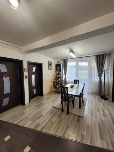 a dining room with a table and a christmas tree at Apartament Eva in Râşnov