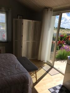 a bedroom with a bed and a sliding glass door at Chambre grise in Barbâtre