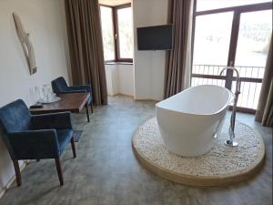 bagno con vasca, sedia e tavolo di Osonnya Karpaty RESORT MEDICAL & SPA a Skhidnytsia