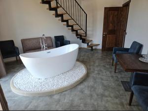 a white bath tub sitting in a room with stairs at Osonnya Karpaty RESORT MEDICAL & SPA in Skhidnitsa