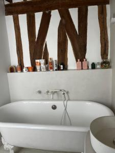a white bath tub in a bathroom with wooden beams at Deux chambres en plein cœur de Montmartre, Paris in Paris