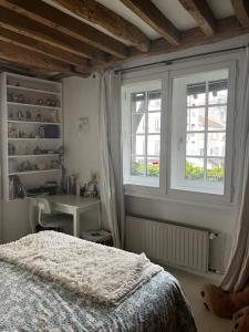 a bedroom with a bed and two windows at Deux chambres en plein cœur de Montmartre, Paris in Paris