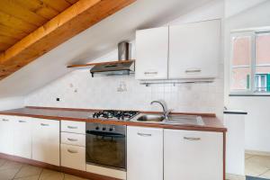 a kitchen with white cabinets and a sink at Marinella, borgo dei pescatori in Cervo +10 photos