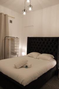 a bedroom with a large bed with a black headboard at Résidence Peace in Le Bourget