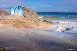 普洛埃默的住宿－RÉF 171 - PLOEMEUR T1 BIS Duplex vue mer，一片拥有蓝色和白色海滩小屋的海滩