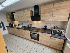 a large kitchen with wooden cabinets and appliances at Gästehaus Bad Dürrenberg in Bad Dürrenberg