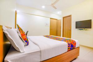 a bedroom with a bed and a flat screen tv at FabExpress Kuber in Navi Mumbai