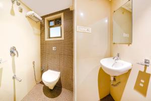 a bathroom with a toilet and a sink at FabExpress Kuber in Navi Mumbai