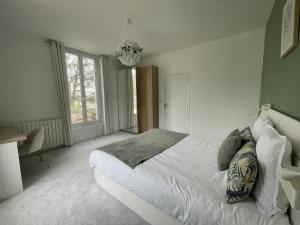 a bedroom with a white bed and a chandelier at Villa Isaac - Luxueuse - Parking - 16p - Rêve au Mans in Le Mans