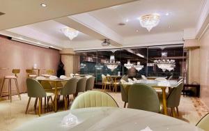 una sala da pranzo con tavoli, sedie e lampadari a braccio di T Hotel a Taichung