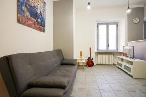 uma sala de estar com um sofá e uma televisão em Montalto House em Turim