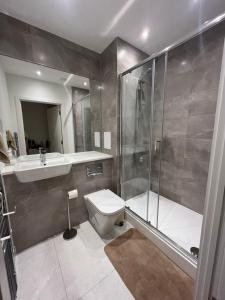 a bathroom with a shower and a toilet and a sink at Private ensuite room near London in Dagenham