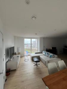 a white living room with a couch and a table at Private ensuite room near London in Dagenham