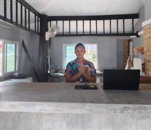 a man is sitting at a table with his hands up at Siri Maya Garden Home Samui in Koh Samui  +63 photos