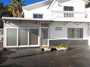 a white house with two potted plants in front of it at Espacio Kybalion in Argentona