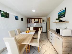 uma cozinha e sala de jantar com uma mesa e um micro-ondas em House Turkalj em Grabovac