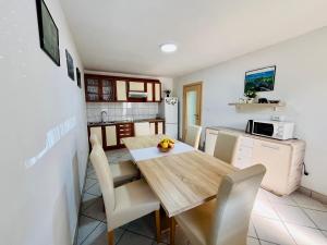 uma cozinha e sala de jantar com uma mesa de madeira e cadeiras em House Turkalj em Grabovac