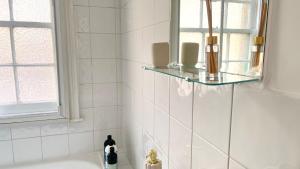 ein Bad mit einer Badewanne und einem Waschbecken mit einem Fenster in der Unterkunft Westminster Apartment in London