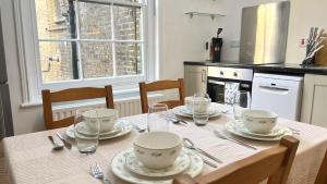 eine Küche mit einem Tisch mit Tellern und Geschirr darauf in der Unterkunft Westminster Apartment in London