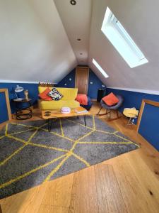 a living room with a yellow couch and a rug at The Cartshed, Coltishall, Norfolk in Norwich