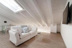 sala de estar con sofá blanco y TV en Incanto Del Lago - Como Lake Cosy Apartment en Como