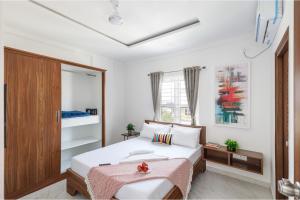 a bedroom with a bed and a window at Olive Serviced Apartments BTM Layout in Bangalore