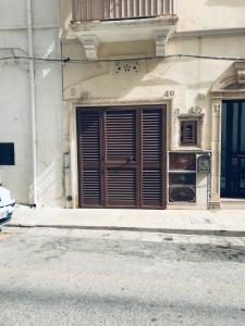 un edificio con una grande porta in legno su una strada di La dimora nel sottano alla strada a Polignano a Mare