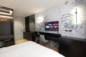 ティラナにあるGremmy Boutique Hotelのベッドルーム1室(ベッド1台、デスク、テレビ付)