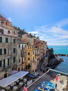 un grupo de edificios junto al océano con barcos en ca' del mare, en Riomaggiore