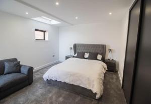 a bedroom with a large bed and a couch at Marine View Apartment By Air Premier in Seaford