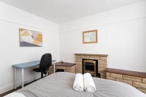 a bedroom with a bed and a desk and a fireplace at May Disc - Long Stay - Contractors in Bristol