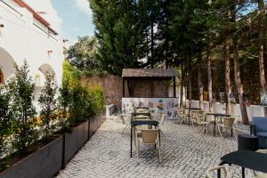 a patio with tables and chairs and trees at Casa Senhoras Rainhas - Óbidos - by Unlock Hotels in Óbidos