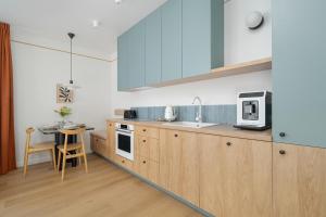 a kitchen with wooden cabinets and a counter top at Unique 2-Bedroom Apartment on the 10th Floor with FREE GARAGE Poznań by Renters in Poznań