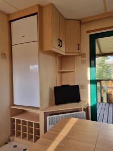 Il comprend une petite cuisine équipée d'un réfrigérateur et d'une table. dans l'établissement Camping Mayet-de-Montagne, à Mayet-de-Montagne