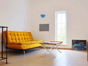 a yellow couch in a living room with a table at Quinta do Lamy - Privat Pool & BBQ & Garden & Privacy & Beach & Benagil in Lagoa