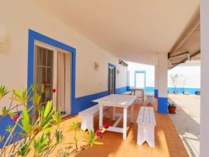 ラゴアにあるQuinta do Lamy - Privat Pool & BBQ & Garden & Privacy & Beach & Benagilの白いテーブルと青い壁のパティオ