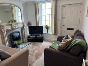 a living room with a couch and a fireplace at Scotch Terrace - 3 Bed House in Whitehaven