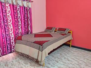 uma cama num quarto com paredes e cortinas cor-de-rosa em Trinity Villa - Home Stay em Honāvar