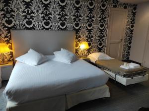 a bedroom with a large white bed and a wall at Hôtel de Paris in Besançon