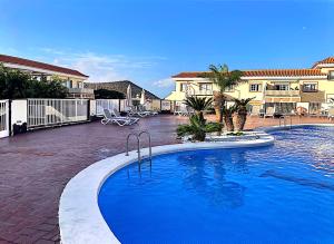 a large swimming pool in front of a house at Piera's Apartment in Chayofa