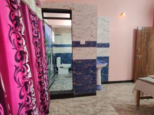 uma casa de banho com uma cortina de chuveiro rosa e um lavatório. em Trinity Villa - Home Stay em Honāvar