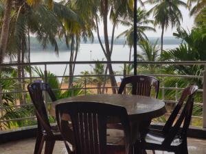 uma mesa com cadeiras e vista para a água em Trinity Villa - Home Stay em Honāvar