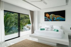 um quarto com uma cama branca e uma grande janela em Villa Murano Samui em Nathon Bay