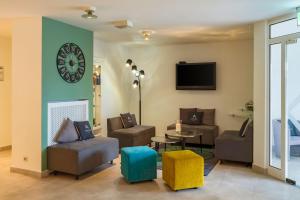 a living room with a clock on the wall at Aspire Frankfurt Airport Rüsselsheim, Trademark Collection by Wyndham in Rüsselsheim